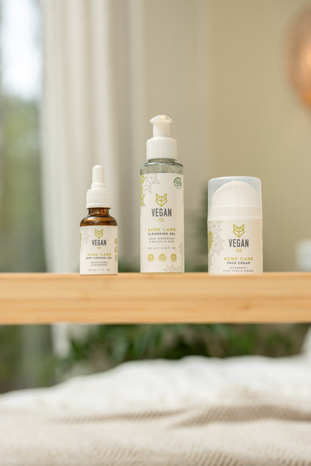 Vegan Fox acne care face set with serum cleansing gel and face cream on wooden shelf