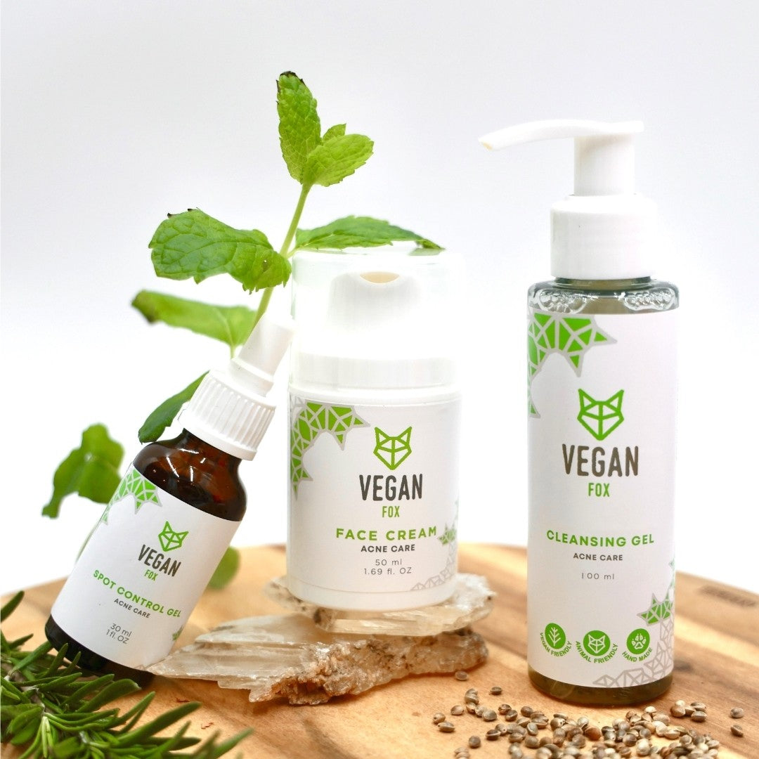 Vegan Fox acne care face set with spot control oil, face cream, and cleansing gel on wooden surface with green leaves