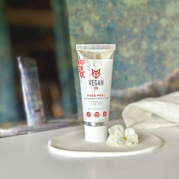 Vegan Fox natural face peel for smoother skin in white tube with floral design on ceramic plate