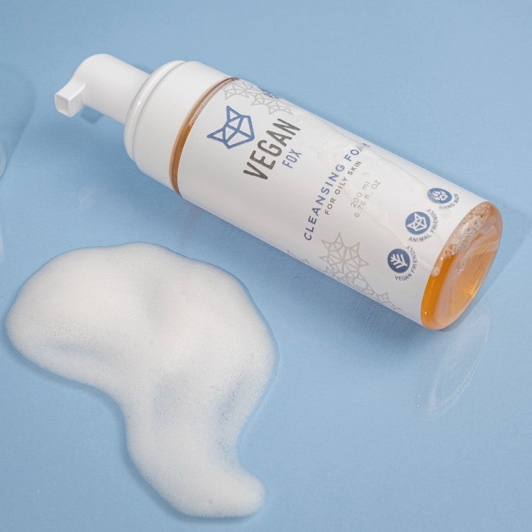 Vegan Fox vegan cleansing foam for oily skin with pump dispenser and foam on blue surface