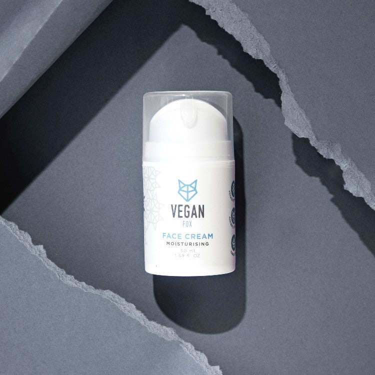 Vegan Fox vegan moisturizing face cream in a white pump bottle on torn gray paper background